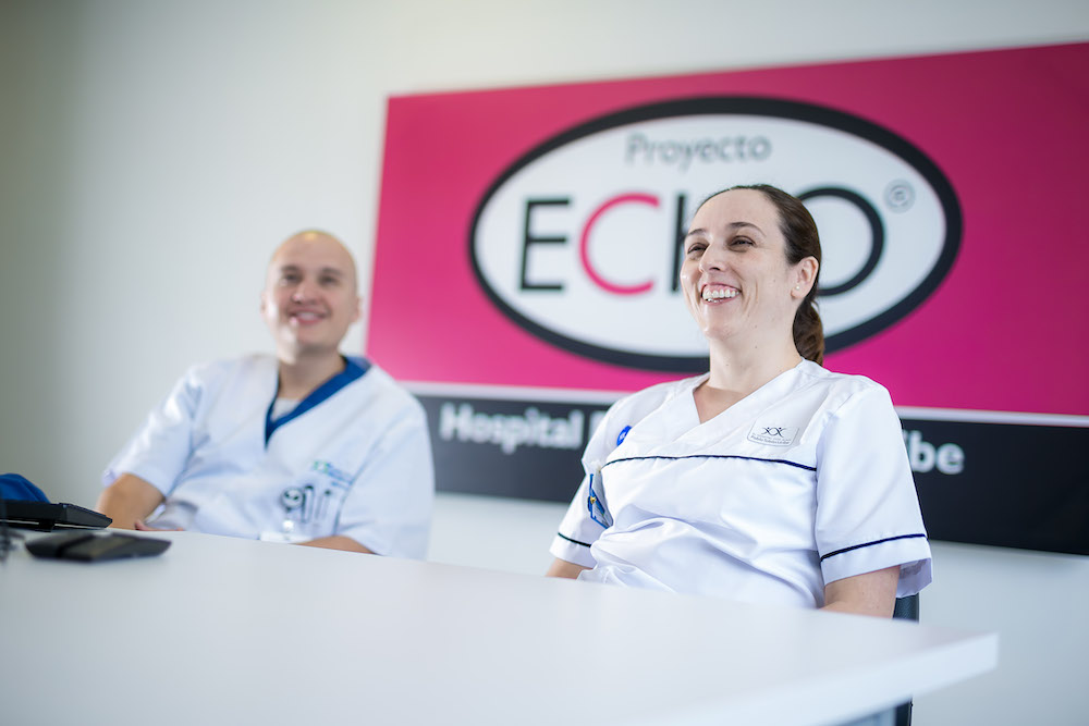 People posing on steps holding up certificates.