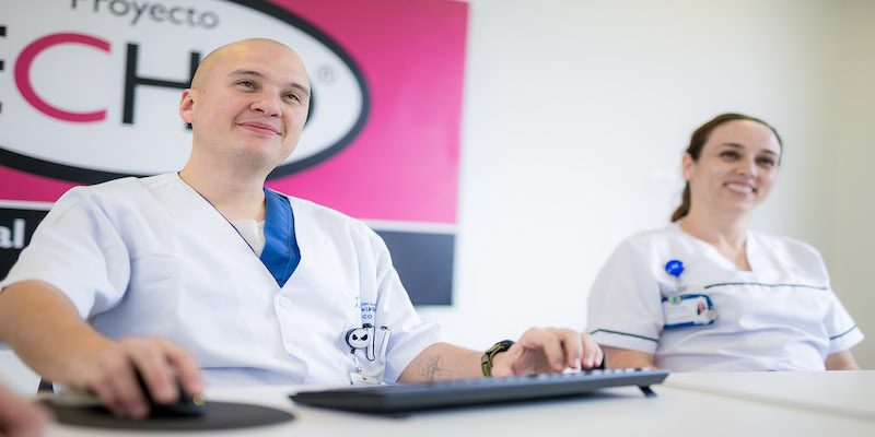 People posing on steps holding up certificates.