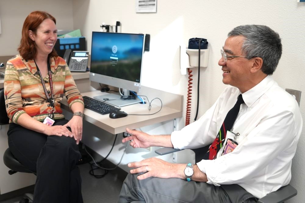Woman talking to men in orange jumpsuits.
