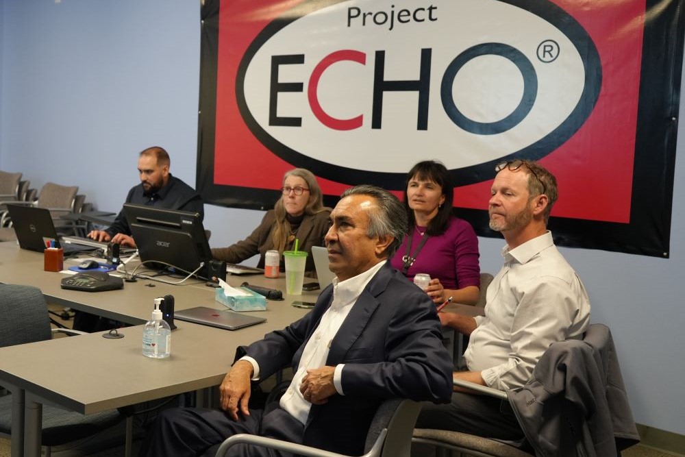 People posing on steps holding up certificates.